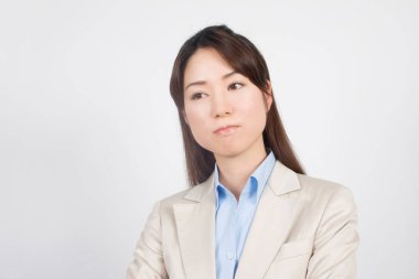 Genç Asyalı iş kadını beyaz arka planda düşünüyor.