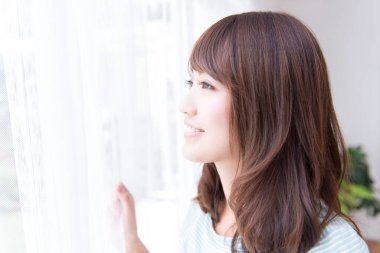 genç kadın evde pencereden arıyor