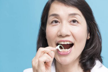 asian woman  using dental Floss pick