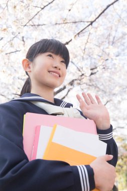 El sallayan kitapları olan güzel Japon öğrencinin portresi.