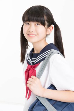 Beyaz arka planda okul üniformalı güzel genç bir öğrencinin portresi.