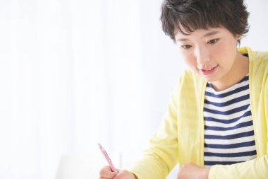 Genç bir kadın not defterine yazıyor.