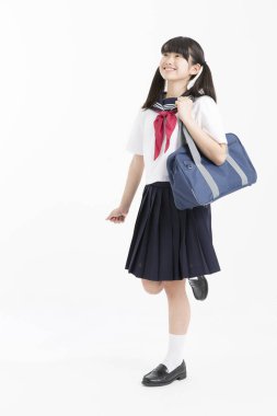 Beyaz arka planda okul üniformalı güzel genç bir öğrencinin portresi.