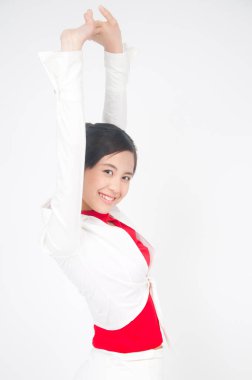 Beyaz takım elbiseli ve kırmızı bluzlu Asyalı kadının stüdyo fotoğrafı.