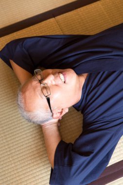 Olgun Asyalı adam yerde dinleniyor.