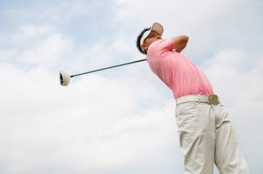 Erkek golfçü golf oynuyor.