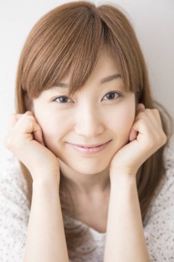 Genç Asyalı kadın evde gülümsüyor, yakın portre. 