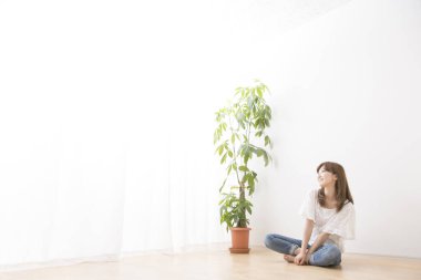 Kadın evinde yerde oturuyor. 