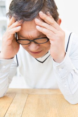 Stresli, başı ağrıyan genç bir adam.