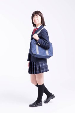 Çantalı gülümseyen Japon öğrencinin stüdyo portresi.