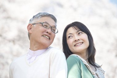 Güzel Asyalı olgun çifti ağaçlarla parka kapatın.