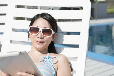 Yüzme havuzunda dijital tablet kullanan kadın