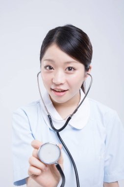 Beyaz üniformalı güzel Asyalı doktorun portresi.