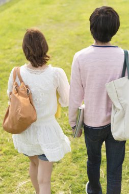 Bir çift mutlu genç Japon öğrenci doğada birlikte vakit geçiriyorlar.