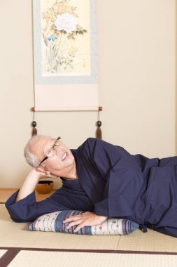 Olgun Asyalı adam yerde dinleniyor.