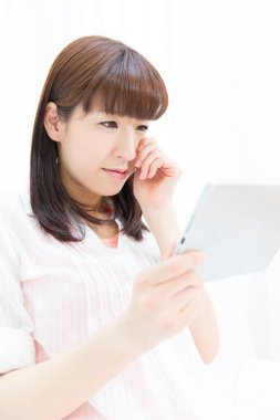 Asyalı kadın evde dijital tablet kullanma 