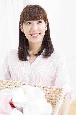 Elinde çamaşır sepeti olan Asyalı bir kadının portresi.