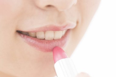 Güzel Asyalı genç kadın kırmızı ruj sürüyor.