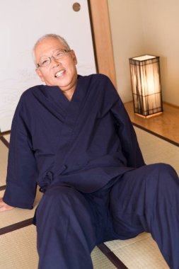 Olgun Asyalı adam yerde dinleniyor.