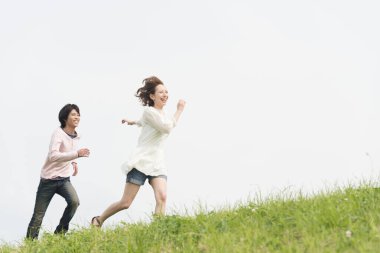 Mutlu genç Asyalı çift yaz parkında koşuyor