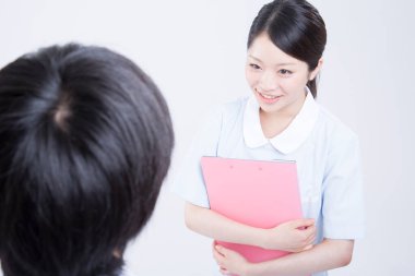 Hastanedeki hastasıyla birlikte gülümseyen genç bir kadının portresi. 