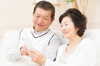 Evde akıllı telefonları olan mutlu çift. 