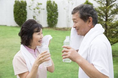 portrait of senior couple drinking water after training 