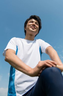 Delikanlı dışarıda egzersiz yapıyor. 