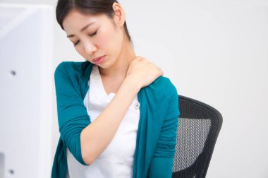 Omuz ağrısı çeken genç bir kadın.