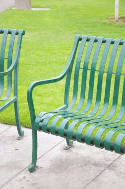 Parkta dinlenmek için boş yeşil banklar