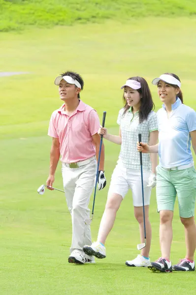asian man and women golf players on the field