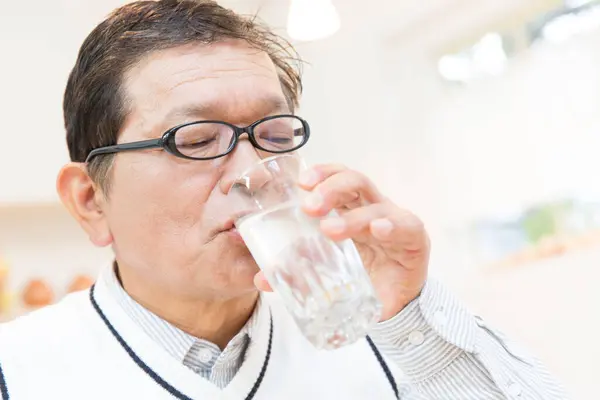 senior asian man drinking water