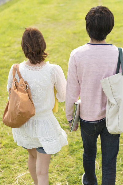 couple of happy young japanese students spending time together on nature