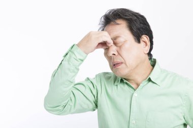 senior  asian man with a headache on white background 