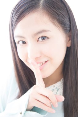 Beyaz arka planda sessiz bir jest yapan genç bir kadın.