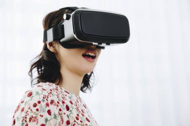 Sanal gerçeklik gözlüğü takan genç bir kadın..