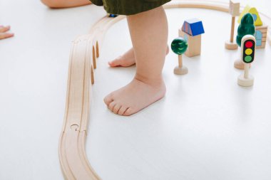 Küçük çocuk ahşap tren istasyonuyla oynuyor. 