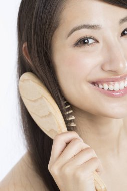 Güzel Japon kadın saçını tarıyor beyaz arka planda.