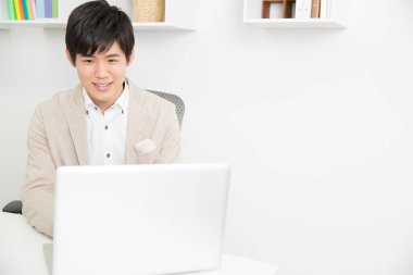 Asyalı işadamı bilgisayarını kullanıyor.