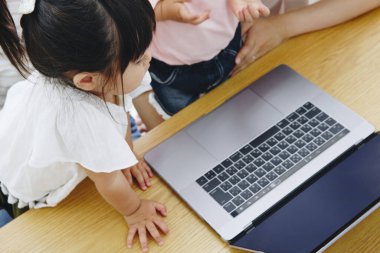 Asyalı tatlı kızlar evde dizüstü bilgisayarla oynuyorlar. 