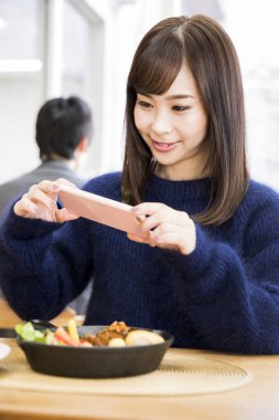 Genç Japon kadın akıllı telefon kullanıyor.