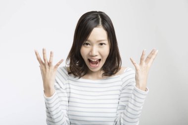 Şaşırtıcı yüz ifadesi olan genç Asyalı kadın çığlık atıyor.