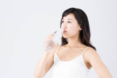 Genç Asyalı kadın bir şişe sudan içiyor. yüksek kaliteli fotoğraf