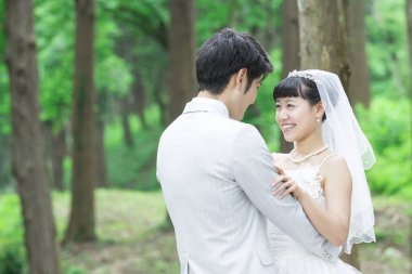 Parkta poz veren Asyalı gelin ve damat 