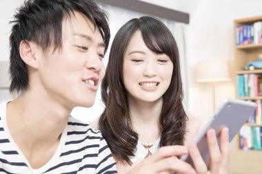 Tablete bakan mutlu Asyalı çift