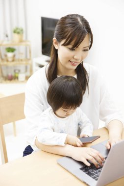 Annesi ve kızı dizüstü bilgisayarlı.