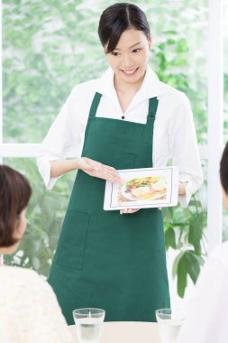 Kafedeki çekici Asyalı genç bayan garsonun portresi