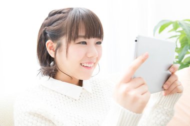 Güzel Japon kadın evde tablet kullanıyor.