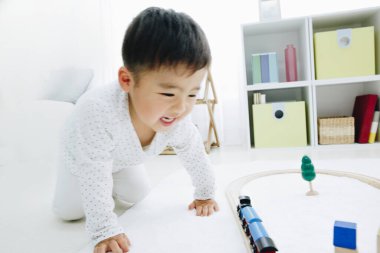 Şirin Japon çocuk evde oyuncaklarla oynuyor.