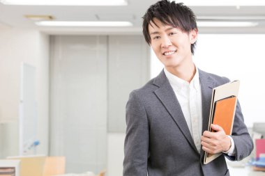 businessman in office holding a folder and smiling